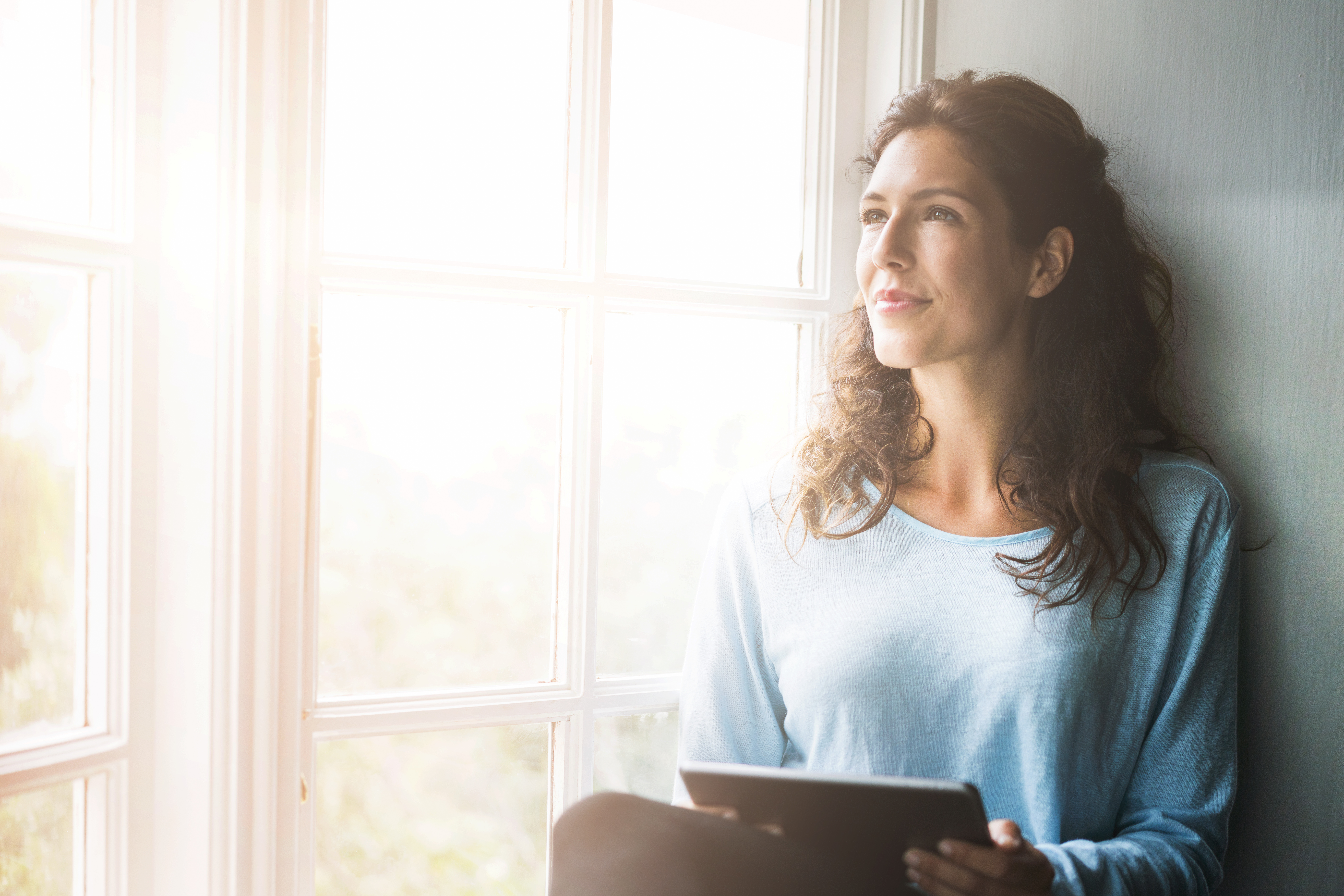 Woman sitting in window with sunlight
