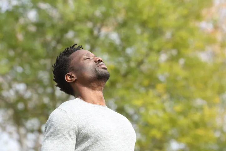 Man breathing deeply outside