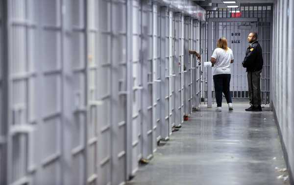 BEAU CABELL/THE TELEGRAPH Bibb County deputy Stanley Sledd, right, and jail nurse Pat Johnson make their way this month through a 20-cell block where Johnson’s job is to dispense medicines to some of the more than 140 inmates diagnosed with mental illnesses at the jail.